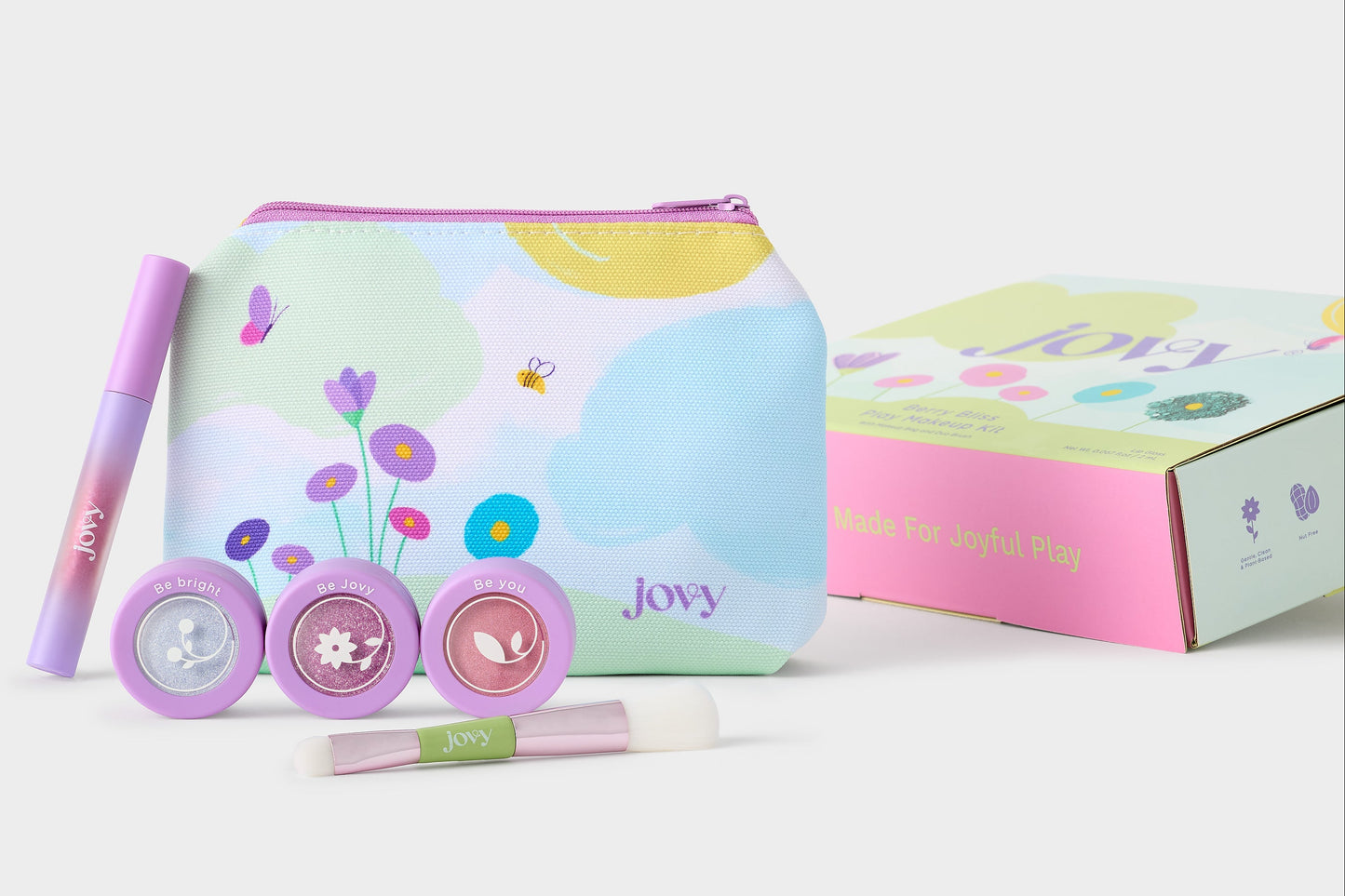 Jovy Berry Bliss makeup gift set featuring a pastel zippered pouch with floral and cloud illustrations, three round eyeshadow and blush containers, one lip gloss, and a duo makeup brush with a branded gift box on a clean white background.