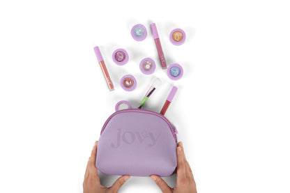 Jovy Glow Up Makeup Bag with eyeshadows and lip glosses spilling out on a white background